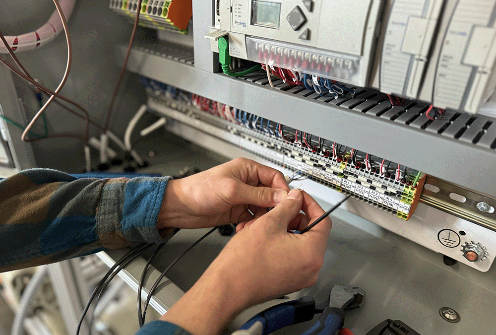 Photo containing PPT technician working on electrical panel for water system